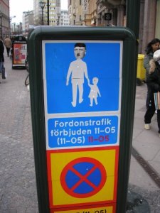 Pedestrian street sign with altered head to show Hitler, and child, in Malmö, Sweden